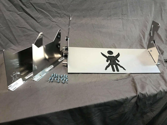 A metal object with multiple parts, screws, and bolts is arranged on a fabric background. The main piece features an engraved design resembling a stylized figure with arms and legs outstretched. Other components include brackets, side panels, and the Miata Sturdy Boii Splitter Mounts '90-05 NA/NB by 9livesracing for increased downforce.