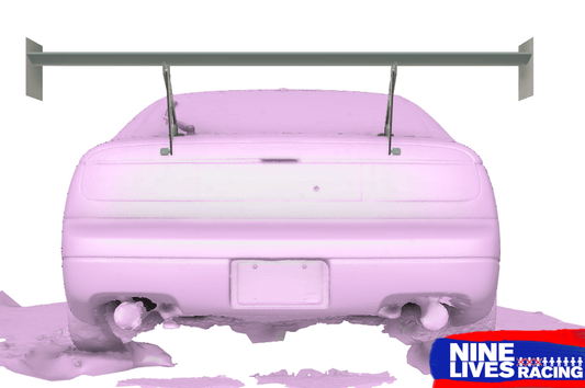 A rear view of a race car is covered in a pink fluid, likely from a wind tunnel test, highlighting its aerodynamics. The 300ZX Big Wang kit '88-00 Z32 features a large rear wing enhancing down-force and dual exhaust pipes. The bottom right corner showcases the "9livesracing" logo in blue and red.