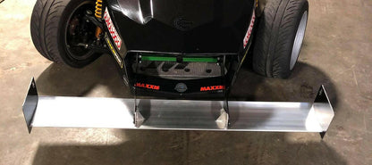 A close-up view of the front of a black race car, showcasing its wheels and newly installed aerodynamic Exocet Chrome Horn Nose Wang Kit by 9livesracing. The kit, featuring side fins and aluminum wings, is designed to improve the car's downforce and stability at high speeds.