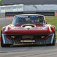 A maroon race car equipped with the wide body kit and a sizable carbon wing from 9livesracing's "The Deuce! Carbon Double Element Kit" is captured in motion on a race track, skillfully navigating around orange traffic cones. The car boasts aggressive aerodynamic features and meticulous modifications, showcasing its design for high-performance racing.