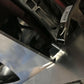 A close-up view shows a Miata Diffuser '90-05 NA/NB by 9livesracing being clamped in place with a tool. The diffuser is part of an assembly or structure, with a screw and some mechanical components visible in the background. There is a barcode sticker on the clamp.