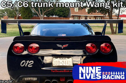 Photograph of a black Chevrolet Corvette featuring a Texas license plate JDD-2441 and adorned with a substantial Nine Lives Racing aluminum wing mounted on the trunk. The vehicle displays the number "012" on its bumper. The top of the image showcases "Corvette Big Wang Trunk Mount Kit '97-13 C5/6," while the bottom right corner bears the 9livesracing logo.