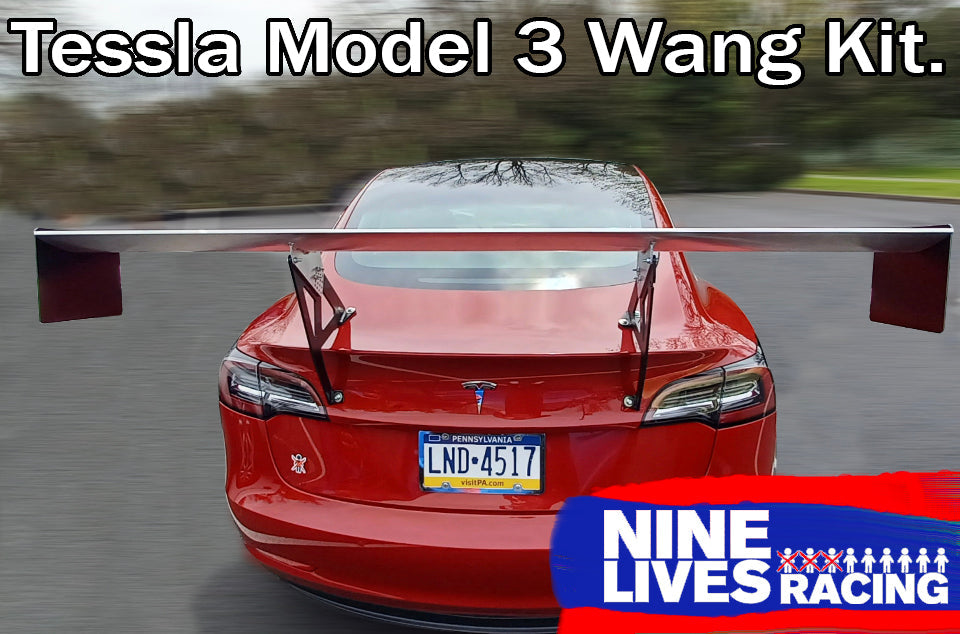A red Tesla Model 3 is shown from the rear with a large aftermarket racing wing kit attached for maximum down-force. The text at the top reads, "Tesla Model 3 Big Wang kit." There's a "9livesracing" logo at the bottom-right corner. The car has a Pennsylvania license plate.