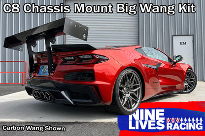 A red sports car, featuring a large black carbon fiber rear wing, is parked in front of a corrugated metal building with a white door numbered 1114. Text on the image reads: "Corvette Big Wang Chassis Mount ’2020 C8" and "9livesracing." This setup maximizes down-force while optimizing the lift-to-drag ratio.
