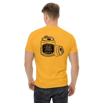 A man wearing a bright yellow Men's Soda Can Wang t-shirt from Nine Lives Racing, featuring a graphic on the back with a can labeled "Nine Lives" accompanied by two additional can illustrations. The man is facing away from the camera, showcasing his short brown hair and dark jeans—a perfect example of layered streetwear outfits.