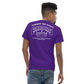 A man with short curly hair is seen from the back, donning a men's classic tee in purple and denim jeans. The Aerodynamics Is Witchcraft T shirt (ouija) from Nine Lives Racing is made of 100% cotton and features white text and a graphic resembling a Ouija board, with phrases like "SUMMON THE SPEED" and "NINE LIVES," making it a standout piece for streetwear outfits.
