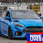 A blue Ford Focus with a large rear wing is showcased in a service area, with "Focus/RS Big Wang Kit '11-18 3rd Gen" text above and "9livesracing" branding in the bottom right corner. The car features custom modifications, including aluminum wings, a front splitter, and wide wheel arches for added down-force.